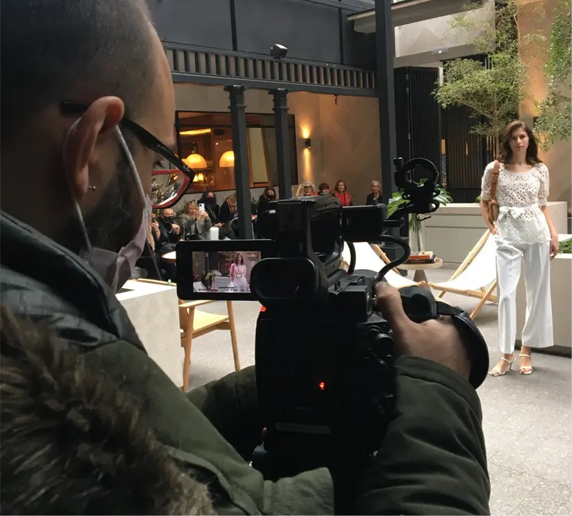 Rodaje de vídeo de moda en exterior con modelo y público en evento