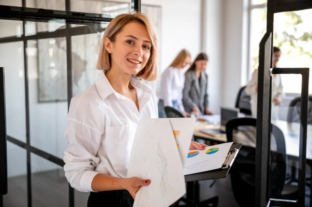 Mujer en oficina durante una sesión de fotografía corporativa en Madrid, con gráficos de empresa en la mano