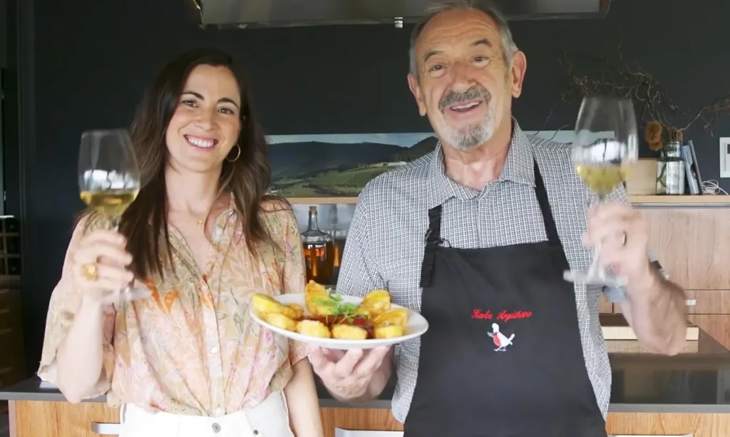 Producción audiovisual de cocina con Karlos Arguiñano y su hija brindando con vino y presentando un plato de gastronomía