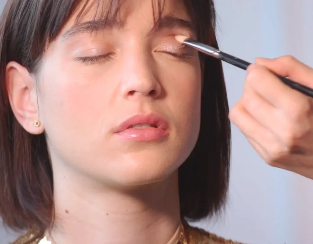Grabación de vídeo tutorial de maquillaje en primer plano, mostrando la aplicación de sombra de ojos paso a paso como parte de un contenido de formación audiovisual