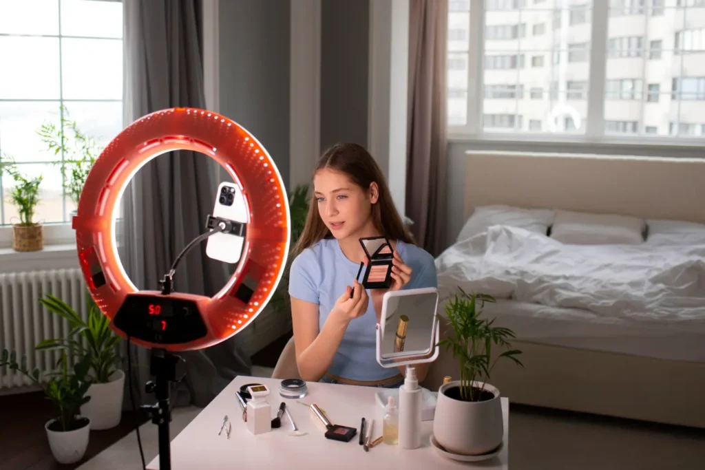 Persona grabando contenido con aro de luz y móvil, ejemplo de tipos de iluminación para grabar vídeo en casa